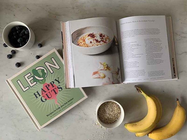 Books on a white marble background surrounded by food items.